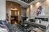 Luxurious living room with modern decor, featuring cozy sofas, a striking geometric rug, and captivating artwork on a textured wall.