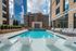 Luxurious rooftop pool area with stylish lounge chairs and fountains, surrounded by a stunning urban skyline.