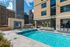 Luxurious rooftop swimming pool with stunning cityscape views, surrounded by comfortable lounge chairs and modern architecture.