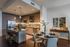 Modern kitchen and dining area with sleek cabinetry, stainless steel appliances, chic pendant lighting, and elegant dining set with stylish decor.