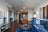 Contemporary open-plan living area with modern decor, featuring a cozy seating space, stylish dining nook, and a sleek kitchen in the background.