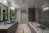 Modern bathroom featuring a sleek double vanity with stylish mirrors, lush greenery, and a luxurious bathtub with glass enclosure.