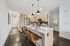 Modern kitchen with sleek wooden cabinetry, stainless steel appliances, and a stylish breakfast bar with leather stools.