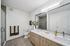Elegant modern bathroom with double sinks, bright lighting, and sleek wooden cabinetry, designed for luxury and comfort.