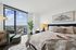 Modern bedroom with expansive city views, featuring chic decor, cozy bedding, and soothing natural light.