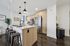 Modern kitchen with sleek wooden cabinetry, stainless steel appliances, and stylish island with chic pendant lighting.