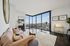 Modern living room with floor-to-ceiling windows showcasing stunning cityscape views, stylish decor, and elegant furniture.