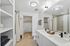 Elegant bathroom with double vanity, modern fixtures, and spacious walk-in closet in contemporary apartment setting.