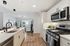 Modern open-concept kitchen and living room boasting sleek stainless steel appliances, cozy seating area, and abundant natural light.