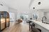 Bright and inviting living space featuring an open-concept design with a cozy living room, modern kitchen with a sleek bar counter, and stylish decor.