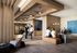 Modern and elegant apartment lobby featuring stylish wooden decor, contemporary lighting fixtures, and a welcoming reception area with guests interacting.