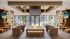 Luxurious modern lounge with plush leather seating, a central fireplace, floor-to-ceiling windows, and elegant decor.
