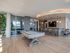 Modern recreation room with elegant pool table, sleek bar with stylish seating, and ambient lighting, perfect for entertainment.