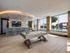 Luxurious game room with a stylish pool table, sleek bar area, and floor-to-ceiling windows offering stunning outdoor views.