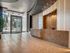 Modern apartment lobby with sleek reception desk, elegant lighting, and large glass entrance doors.