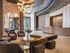 Luxurious apartment lobby featuring modern seating, stylish chandeliers, and a sleek reception desk.