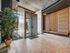 Modern apartment lobby with elegant wood paneling, stylish seating area, and lush indoor plant.