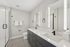 Modern bathroom featuring dual sinks, sleek cabinetry, and a spacious glass-enclosed shower.