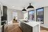 Modern kitchen with sleek island, large windows, and view to cozy bedroom.