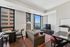 Modern living room with a cozy sofa, stylish furniture, and large windows offering stunning city views.