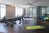 Modern fitness studio with rowing machines, spin bikes, and vibrant exercise balls, ideal for a refreshing workout experience.
