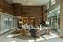 Elegant lounge area with modern decor, featuring plush seating, a grand piano, and floor-to-ceiling windows for ample natural light.
