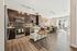 Chic contemporary apartment with sleek kitchen, warm wooden floors, and sunlit living area featuring stylish decor.