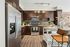 Modern kitchen with sleek stainless steel appliances, dark wood cabinetry, and stylish open shelving, featuring warm wooden flooring and elegant decoration.