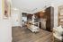 Contemporary kitchen with sleek dark wood cabinets, stainless steel appliances, and a stylish breakfast bar with chic seating.