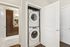 Chic apartment feature with a modern in-unit laundry conveniently tucked away, leading into a stylish kitchen with elegant cabinetry.