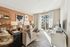 Bright and modern living room with chic decor, featuring a cozy sofa, elegant artwork, and a sunlit balcony. Perfect for stylish urban living.