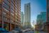 Stunning urban skyline featuring modern high-rise apartments with expansive balconies, set against a beautiful cityscape backdrop at dusk.