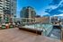 Luxurious rooftop pool with modern lounge area surrounded by high-rise buildings against a stunning evening sky, perfect for urban living.