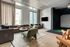 Modern sport simulation room with large windows, chic furniture, and a wall-mounted TV, creating a bright and inviting space.