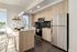 Modern kitchen with sleek stainless steel appliances, elegant light wood cabinetry, and chic breakfast bar overlooking a cityscape.