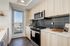 Modern kitchen with sleek appliances, elegant cabinetry, and expansive city views from the window.