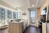 Modern kitchen with sleek appliances, floor-to-ceiling windows, and a stunning city view, creating an inviting and stylish culinary space.