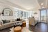 Bright urban apartment with sleek modern kitchen, cozy living area, and expansive city views from large windows.