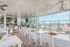 Chic rooftop terrace with modern dining furniture, barbecue area, and stunning city views.