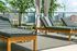 Luxurious rooftop oasis with stylish sun loungers, elegant drapery, and stunning city skyline views.