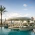 Luxurious rooftop pool with elegant bar seating and stunning city skyline views.