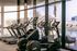 Modern fitness center with state-of-the-art cardio equipment facing a relaxing poolside view.