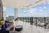 Luxurious courtyard with modern seating and stunning panoramic city views, featuring sleek glass railings and elegant planters.