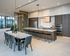 Modern kitchen and dining area with sleek design, featuring a long marble dining table, elegant chairs, and a spacious island with bar stools; perfect for entertaining.