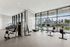 Modern fitness center featuring state-of-the-art equipment with stunning cityscape views through expansive windows.