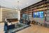 Elegant apartment library with modern chandelier, plush seating, full wall bookshelves, and a contemporary aesthetic.
