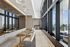 Luxurious lounge area with elegant seating, chic gold tables, and breathtaking panoramic city views through expansive windows.