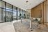 Modern resident lounge area with expansive floor-to-ceiling windows, stylish seating, and a sleek pool table, offering a bright and inviting atmosphere.