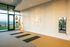 Elegant yoga studio with large windows, soothing lighting, and peaceful decor, offering a serene environment for relaxation.