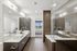 Elegant modern bathroom featuring a spacious glass-enclosed shower, dual sinks, and a luxurious bathtub with city skyline views.